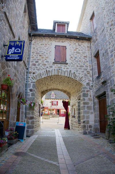 Marcoles petite cite de caractere portail haut donnant sur la place de la fontaine routes touristiques du cantal guide touristique de l auvergne