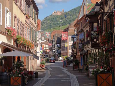 Ribeauville la grand rue et le chateau de saint ulrich en arriere plan route des vins d alsace guide du tourisme de l alsace